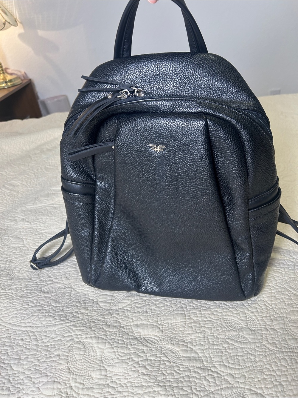 Black Pebbled Leather Daypack Backpack with Subtle Metal Emblem